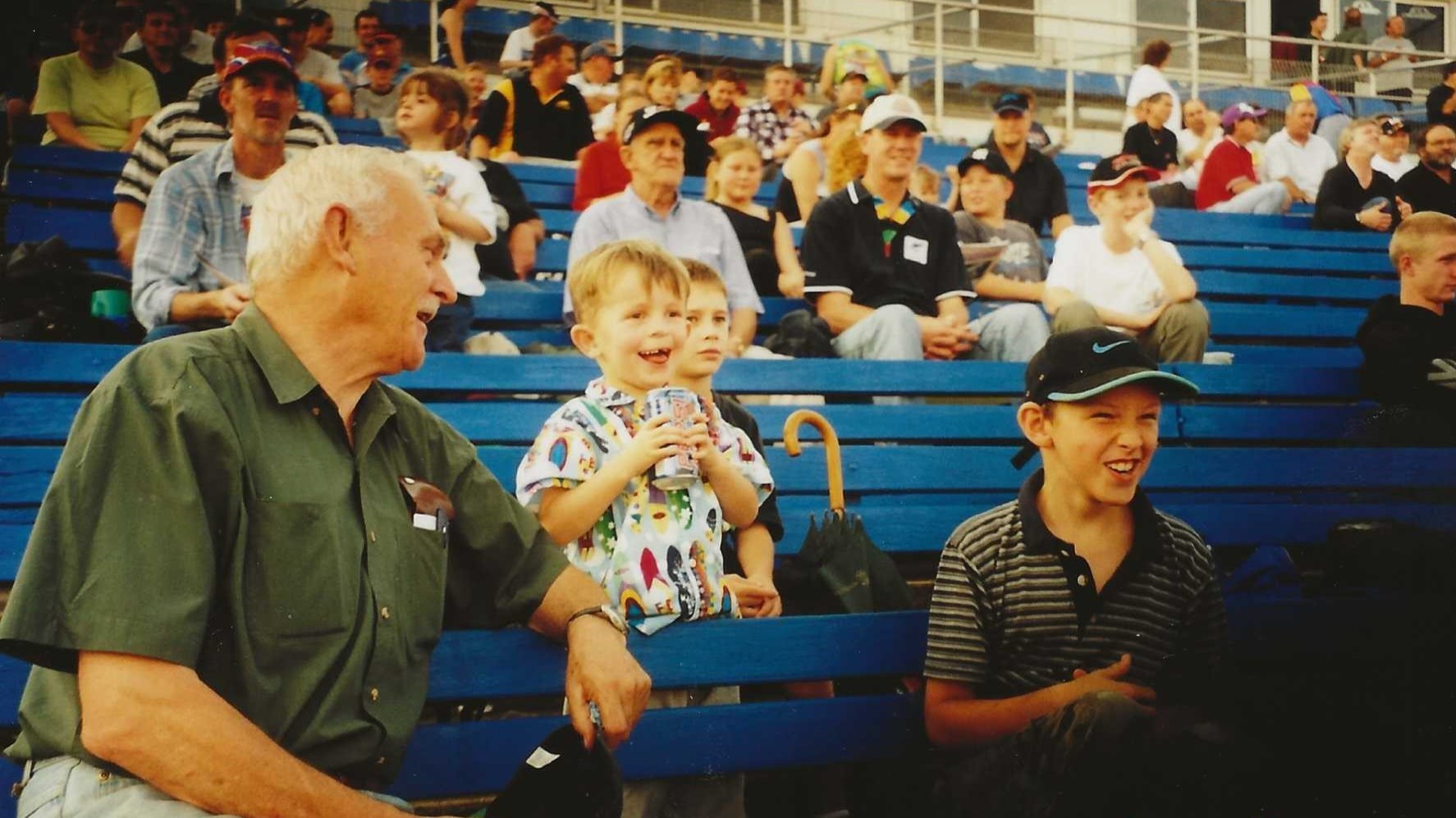Black and white photo of the Nicol family standing together outdoors, with several adults, two children, and a baby held by an older man.