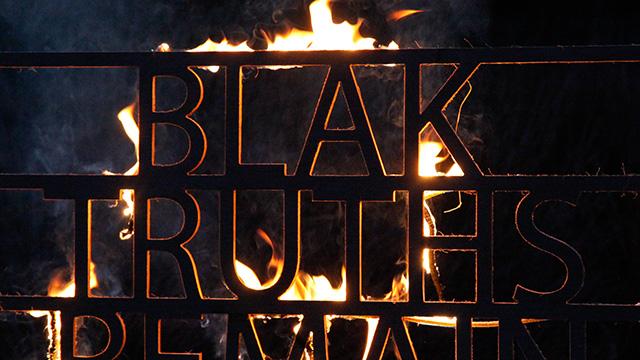 Text reading &ldquo;BLAK RULES&rdquo; set against flames, symbolising strength, pride and resistance.