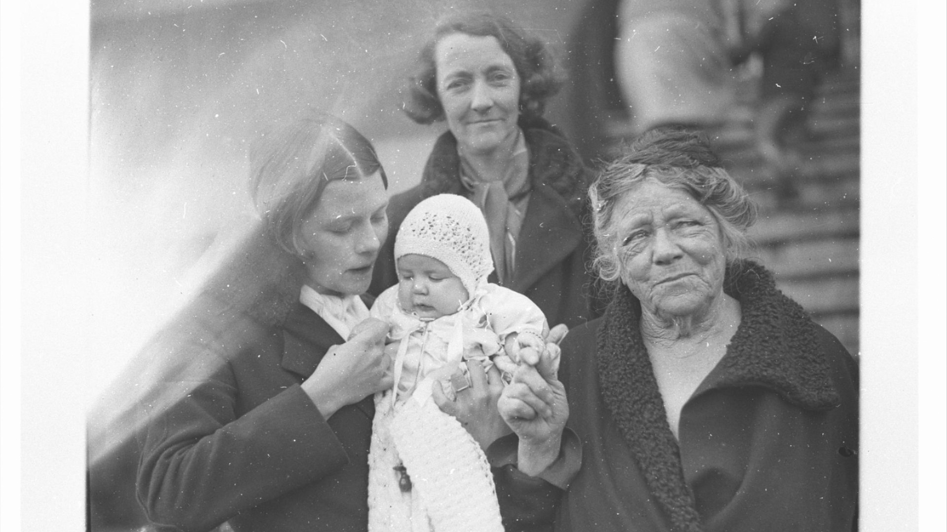 Black and white photo of a mother and grandmother holding a baby.