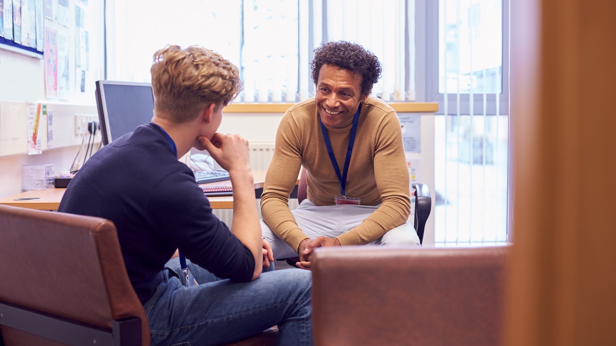 A student talks with a staff member in an office.