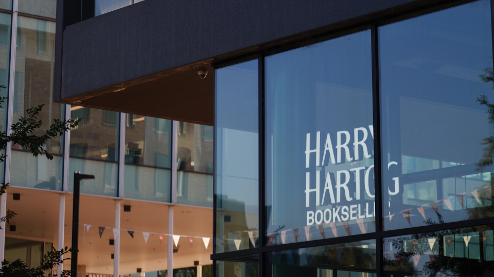 Harry Hartog Bookseller storefront with its logo on large glass windows.