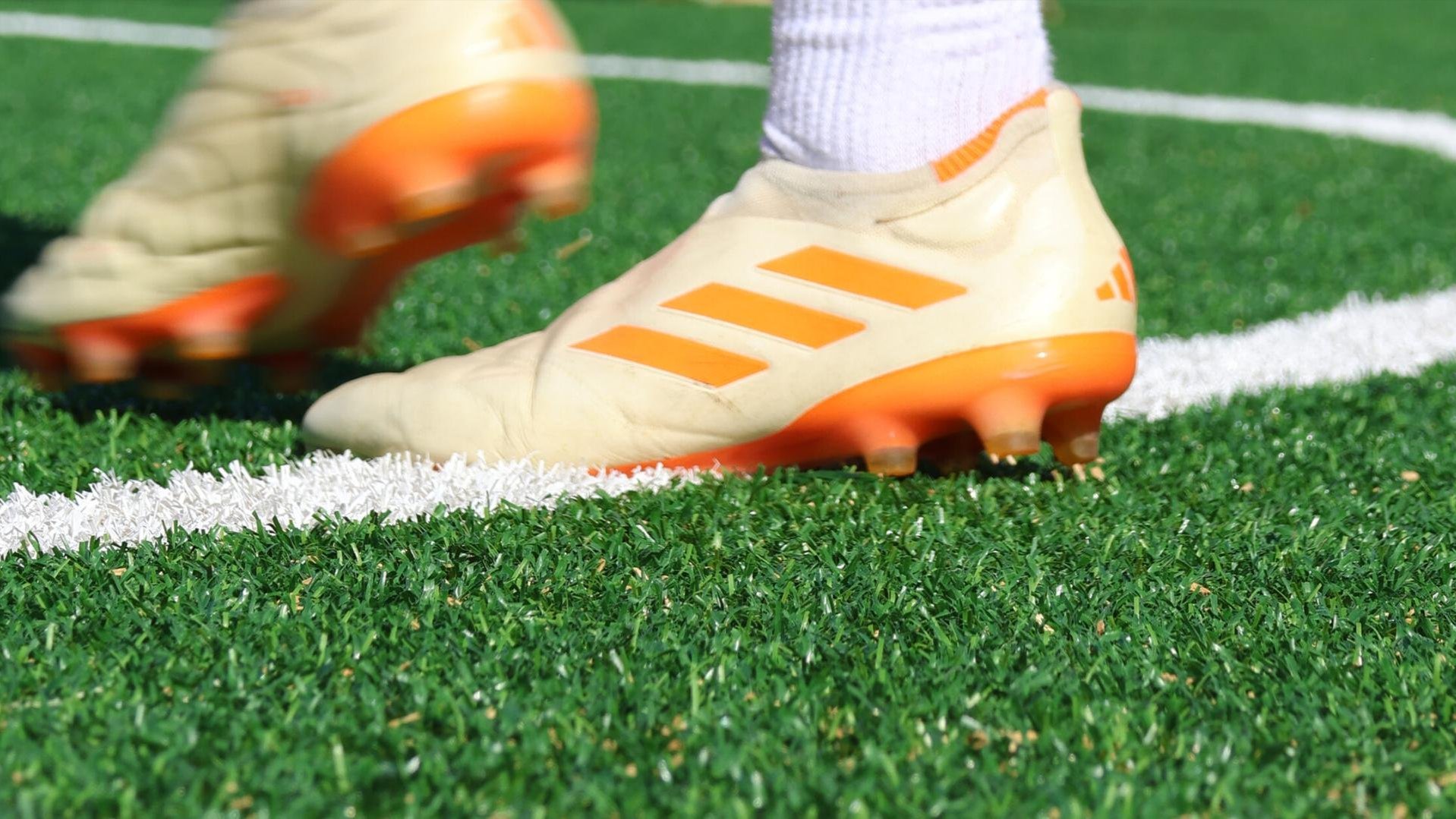 A shot of someone's feet in soccer boots, walking on a soccer field. 