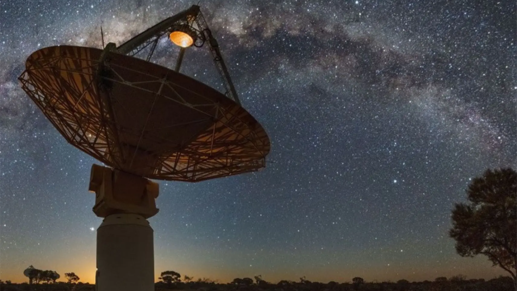Australian Square Kilometre Array Pathfinder (ASKAP) radio telescope dish under a clear night sky with the Milky Way stretching overhead.