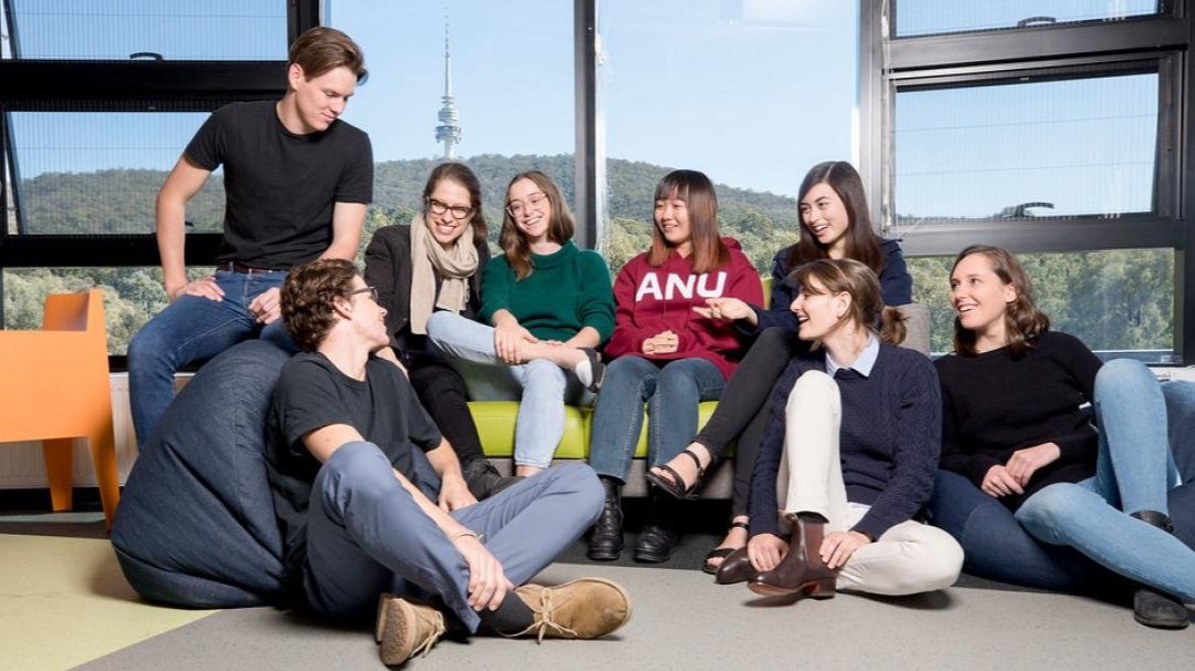 Group of ANU students seated together in a campus common area, talking and listening in a relaxed setting, reflecting respectful relationships and a supportive student community.