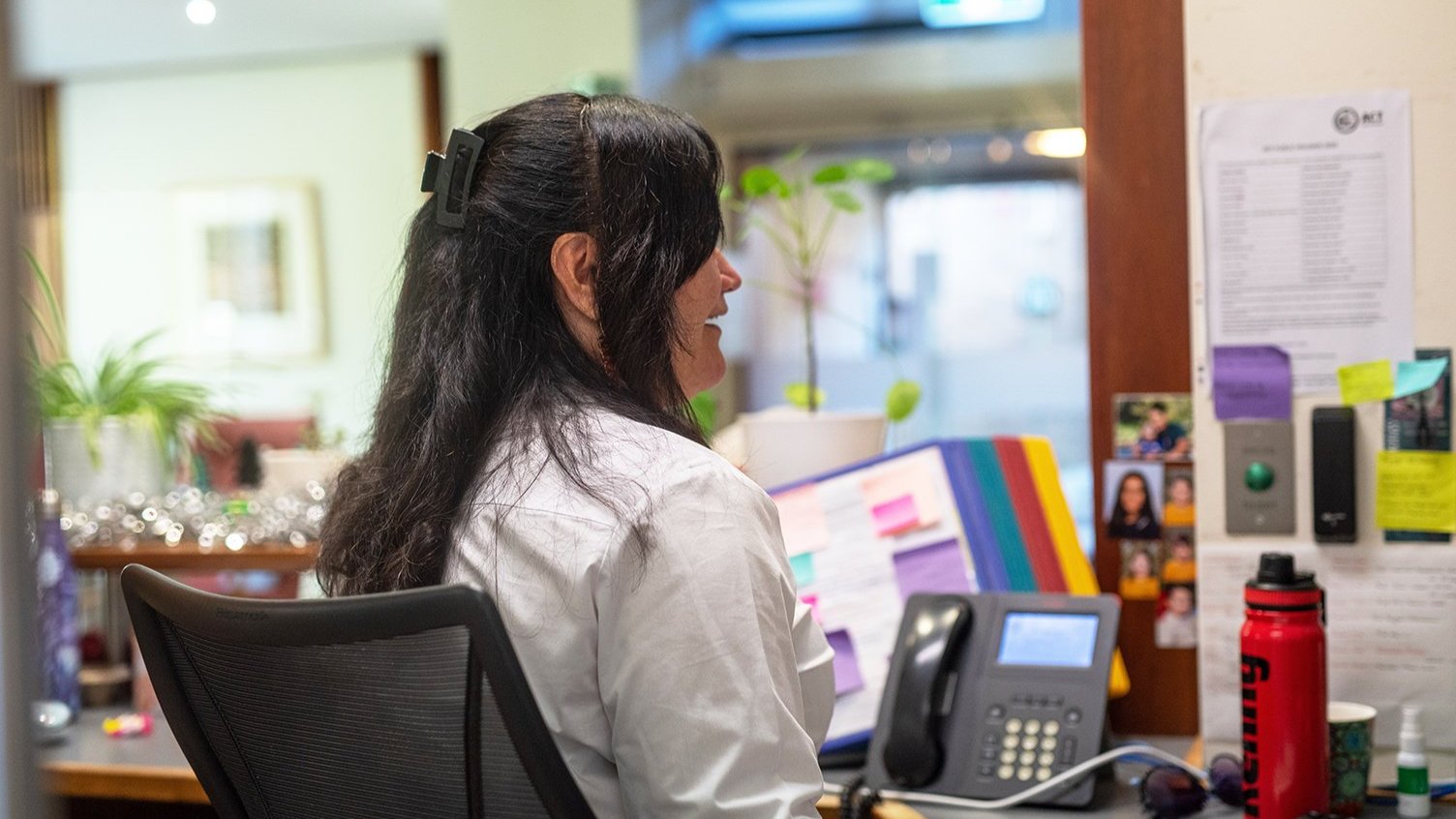 Heather Lambert, Security Professional, seated at her desk in the ������ƵChancelry Building with office equipment around her.