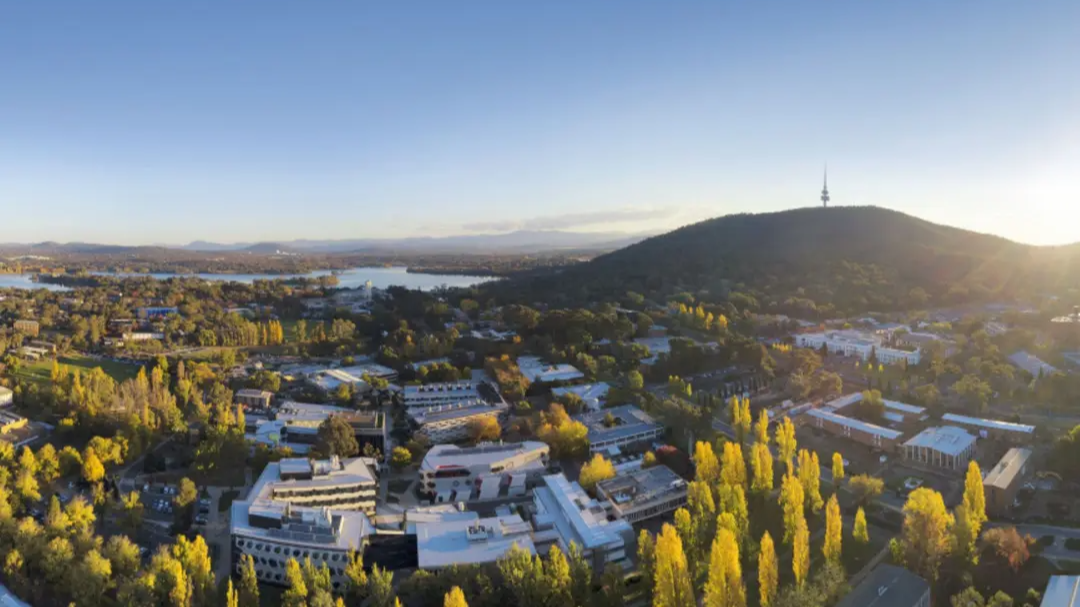 Aerial view of the ANU campus and surrounding Canberra landscape, with Black Mountain and Telstra Tower in the background.