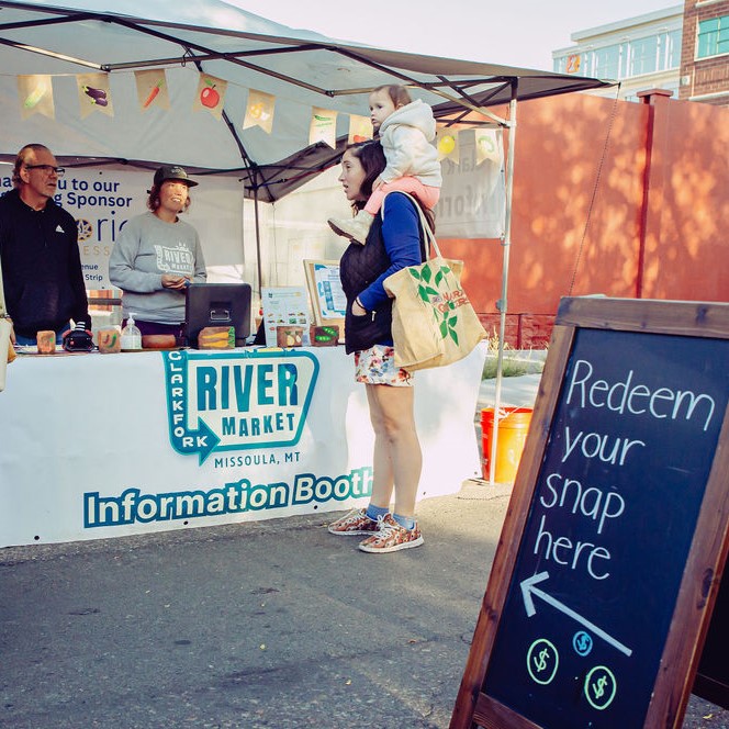 An attendee at the River Market in Missoula, Montana, learns about redeeming SNAP benefits