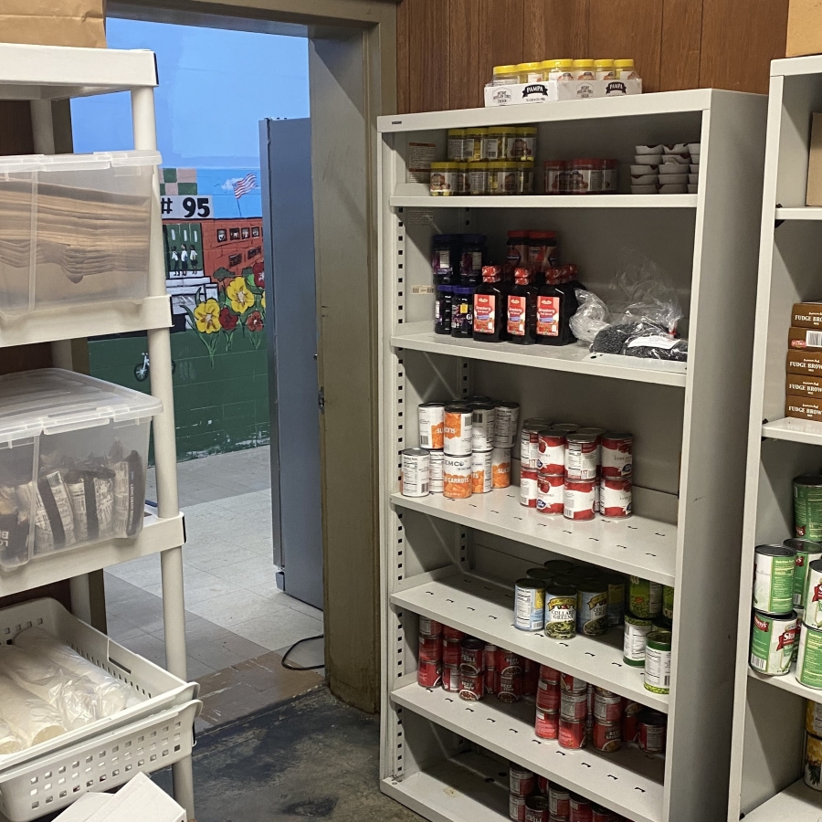 School pantry sneak peak shows the interior of a school food pantry with shelves stocked with nonperishable food items. Photo provided by the authors.