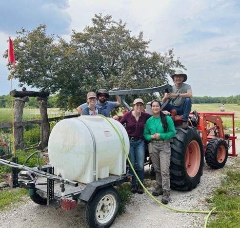 Members of The Land Institute’s soil ecology team pose with the urine tank after the first successful fertilizer application. Photo provided by The Land Institute.