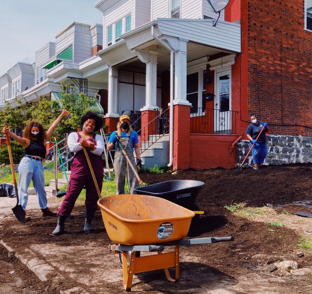 Photo of author Dr. Ashley Gripper (unmasked) and family and friends (masked) converting a vacant lot that was previously full of trash into a community garden. Photo by Wren Rene.