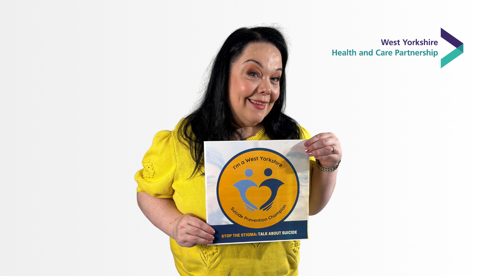 Image of woman smiling and holding a sign that says I'm a West Yorkshire suicide prevention champion