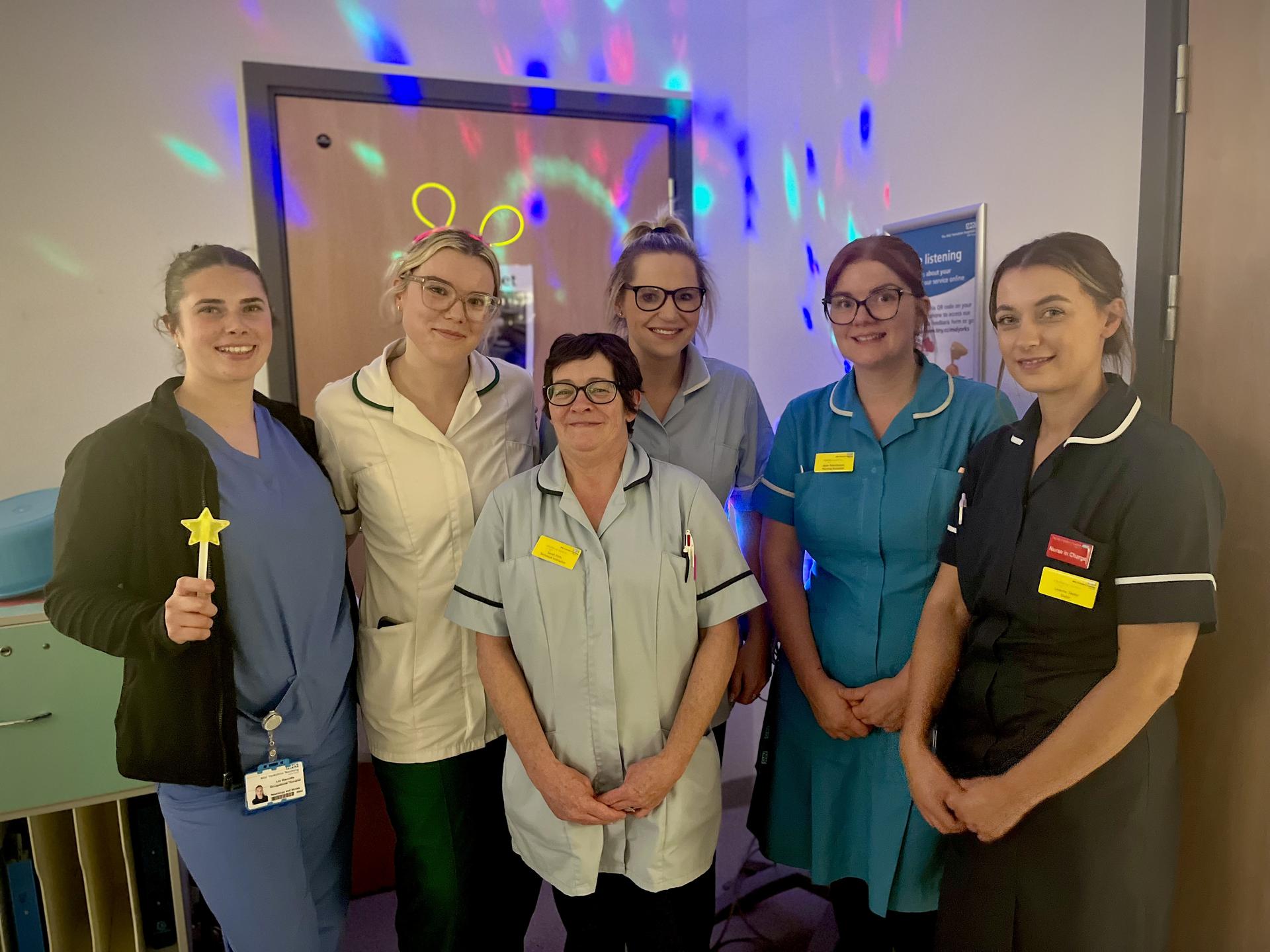 Image of healthcare staff smiling with disco lights 