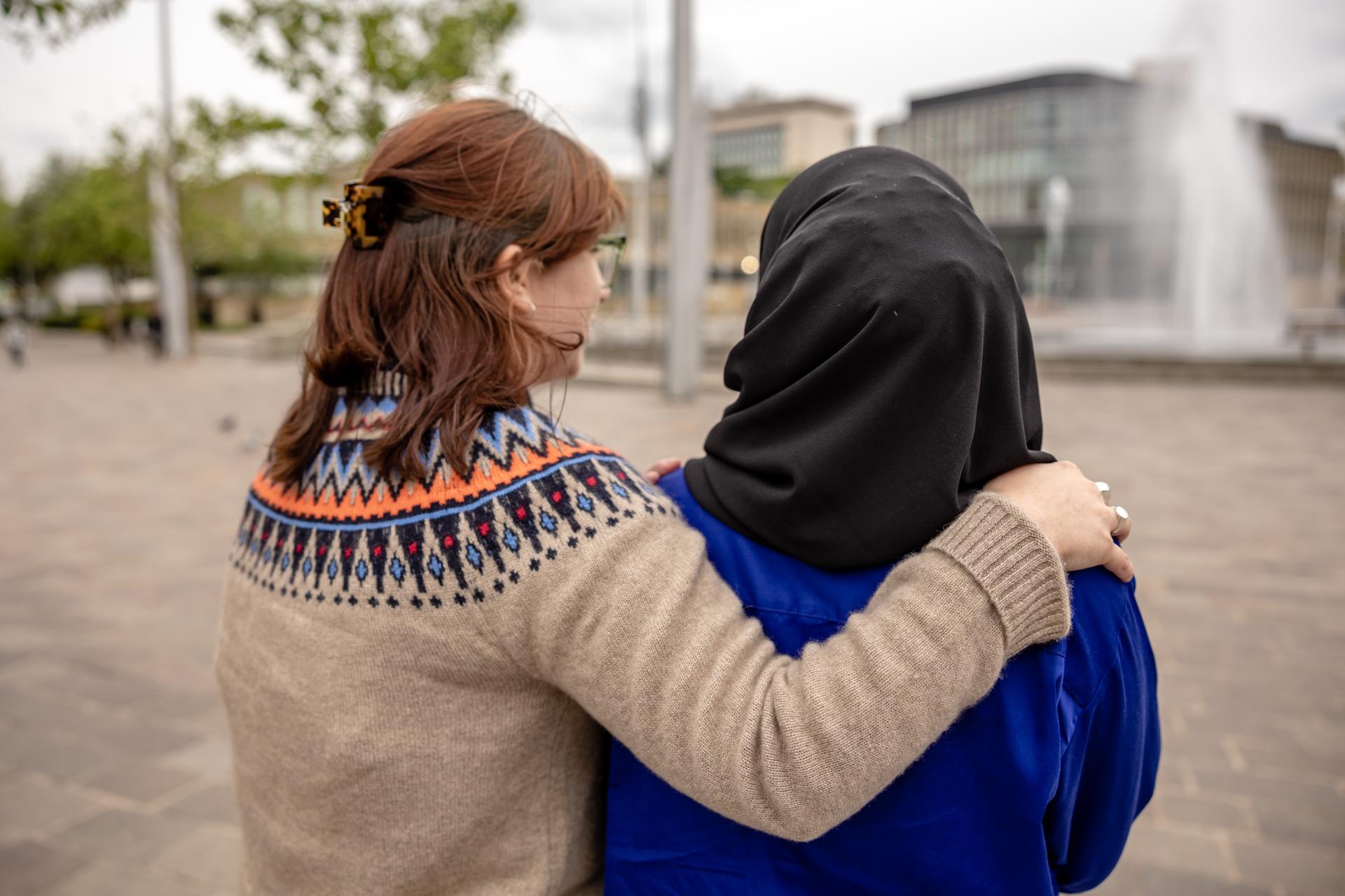 Image of someone with their arm around another person