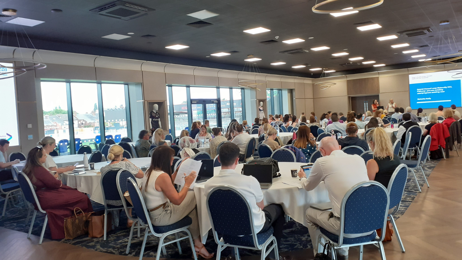 Image from the HCL event of a group of people sat at tables