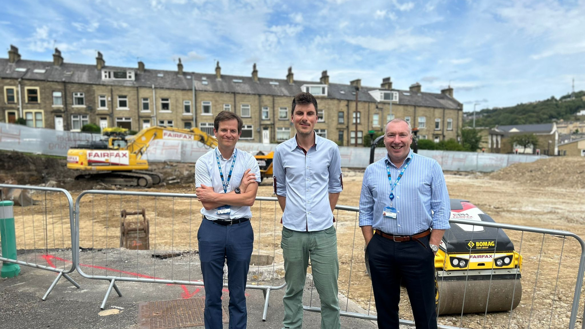 Group of people smiling in front of a construction site