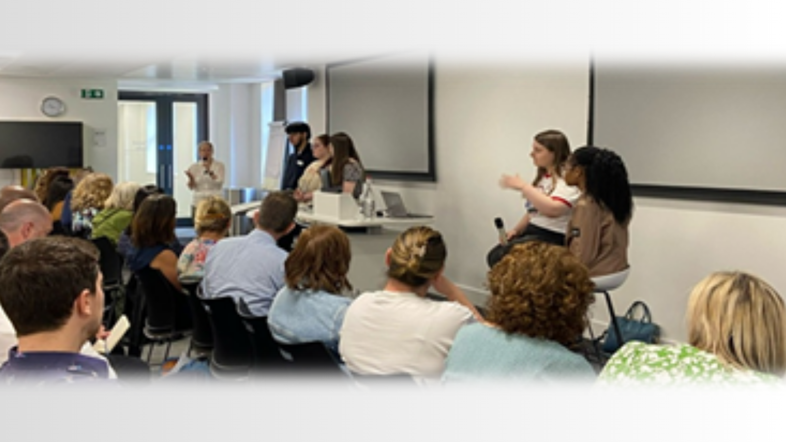 Image group of people speaking at an event in front of an audience