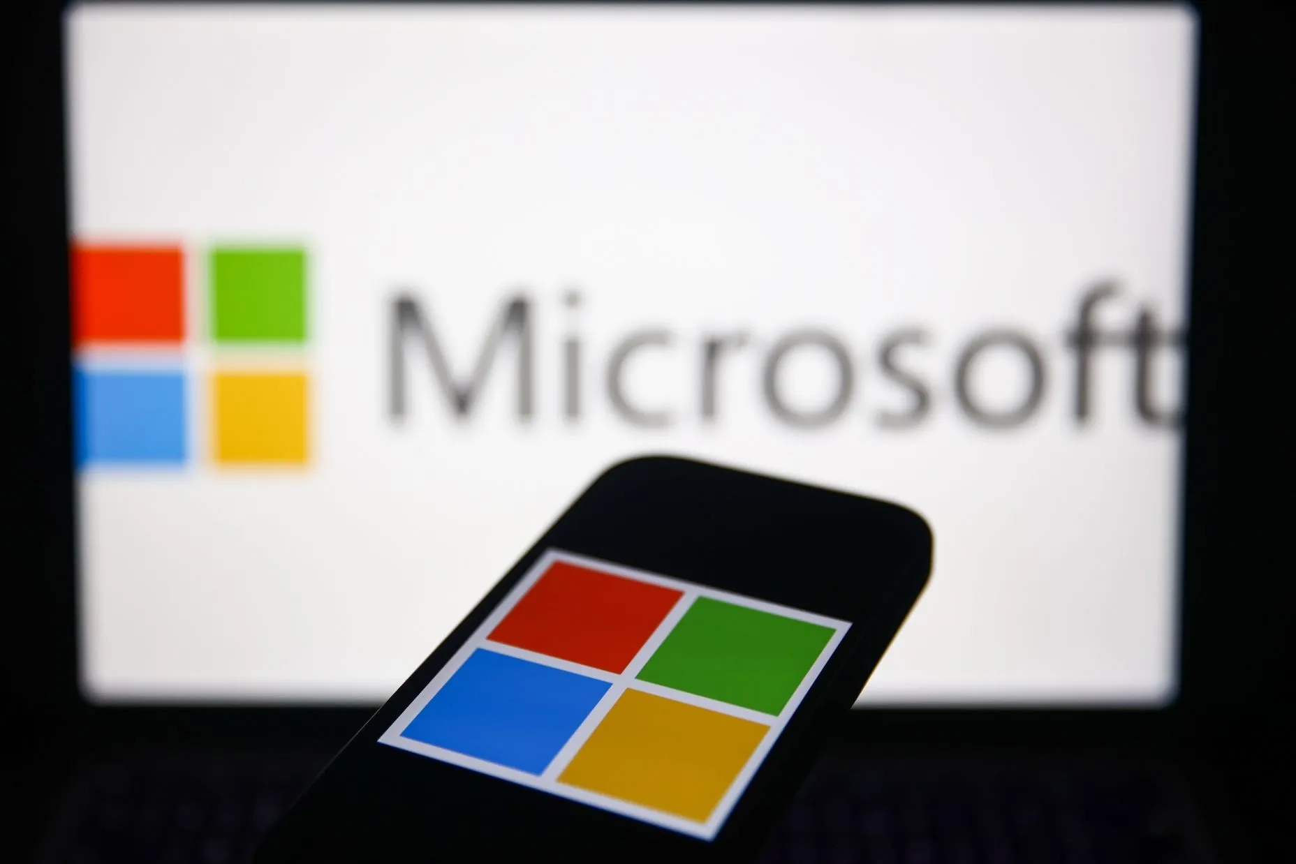 Microsoft logo on computer screen and cell phone