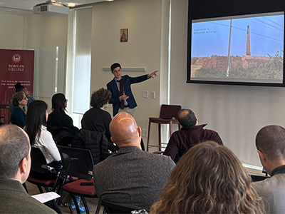 Man standing and giving a presentation to a seated audience.