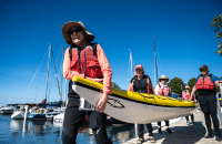 Group of people carrying a canoe on a dock