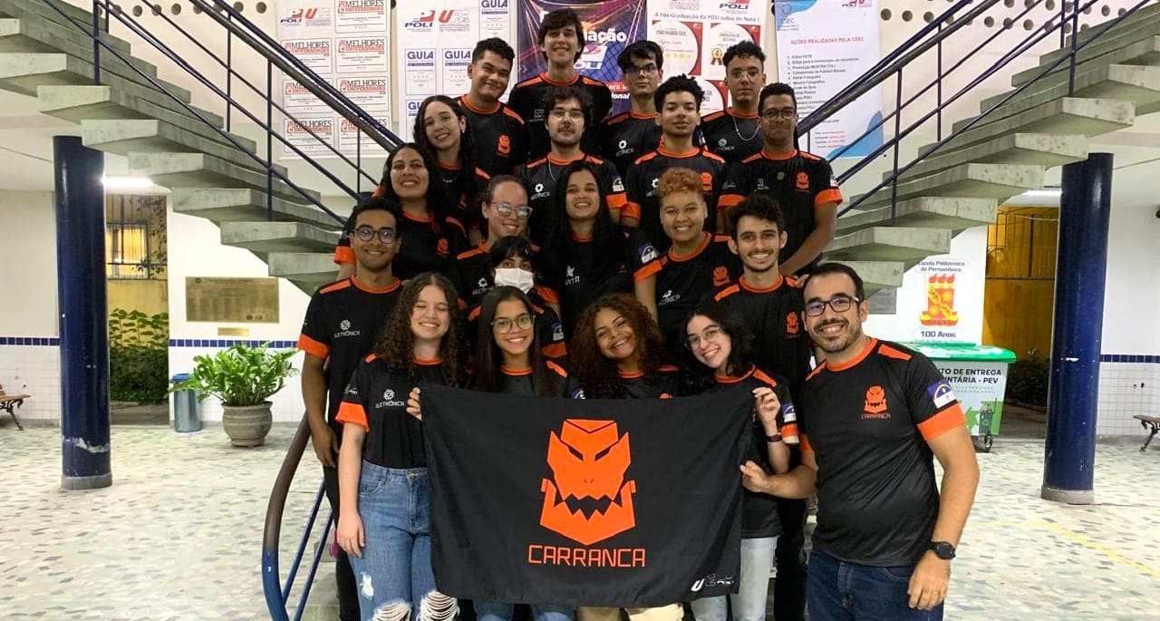 Discentes da POLI segurando a bandeira da Equipe