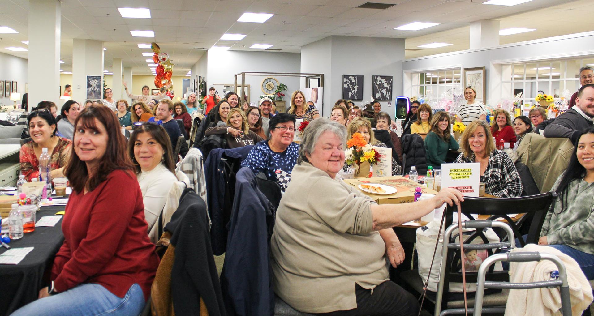Photo of a large group of people sitting at tables enjoying a game of Bingo.