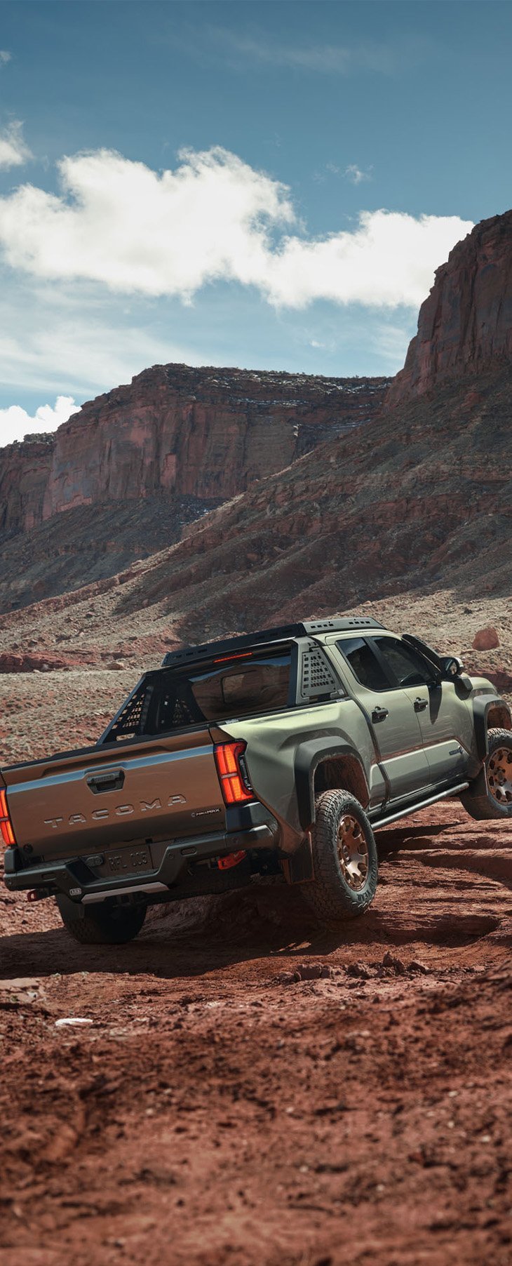 2026 Toyota Tacoma at Delaney Toyota of DuBois in DuBois, PA | Rear profile of a 2026 Toyota Tacoma driving up some rocks 2026 Toyota Tacoma at Delaney Toyota of DuBois in DuBois, PA | Rear profile of a 2026 Toyota Tacoma driving up some rocks