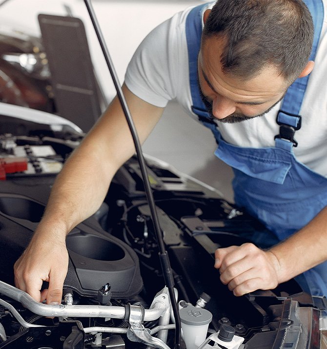 Extend the Life of Your Vehicle at Delaney Chevrolet of Indiana in Indiana, PA | Mechanic inspecting engine bay area