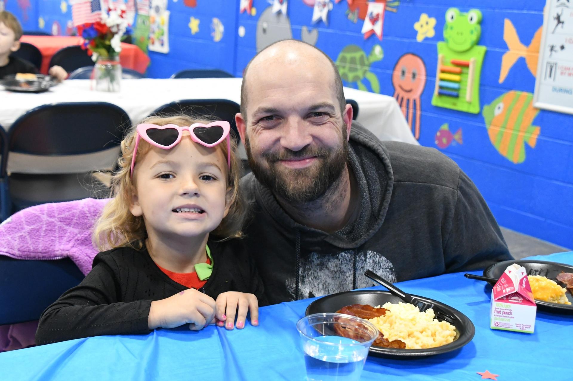 Picture of Veterans Day School Celebrations - student and veteran eating