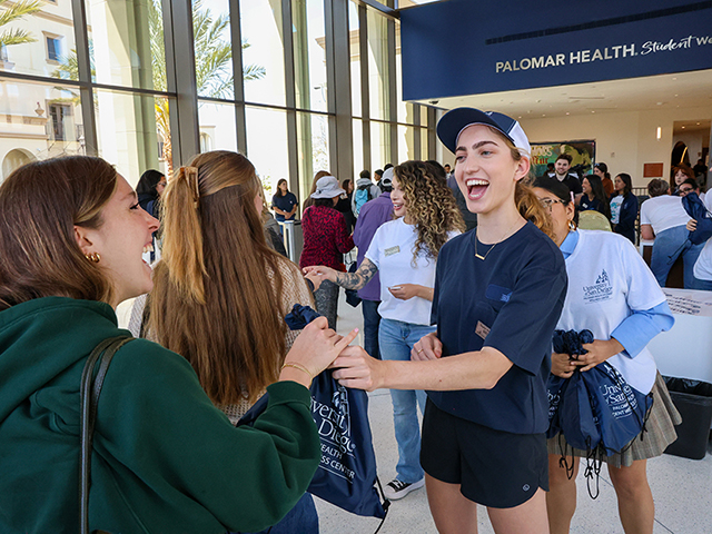USD students receive swag while entering the new Palomar Health Student Wellness Center. 