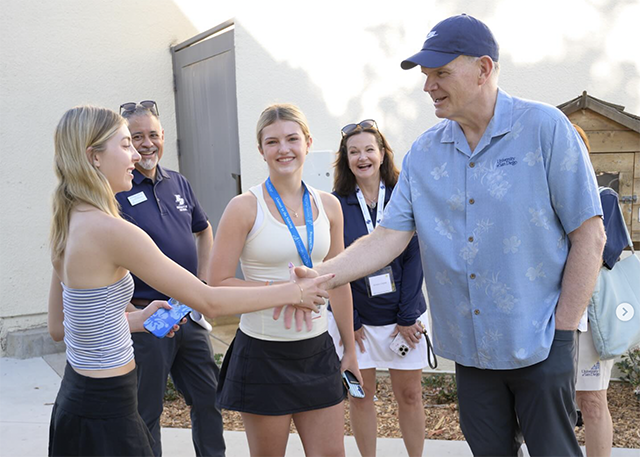 Dr. Harris shakes hands with a student.