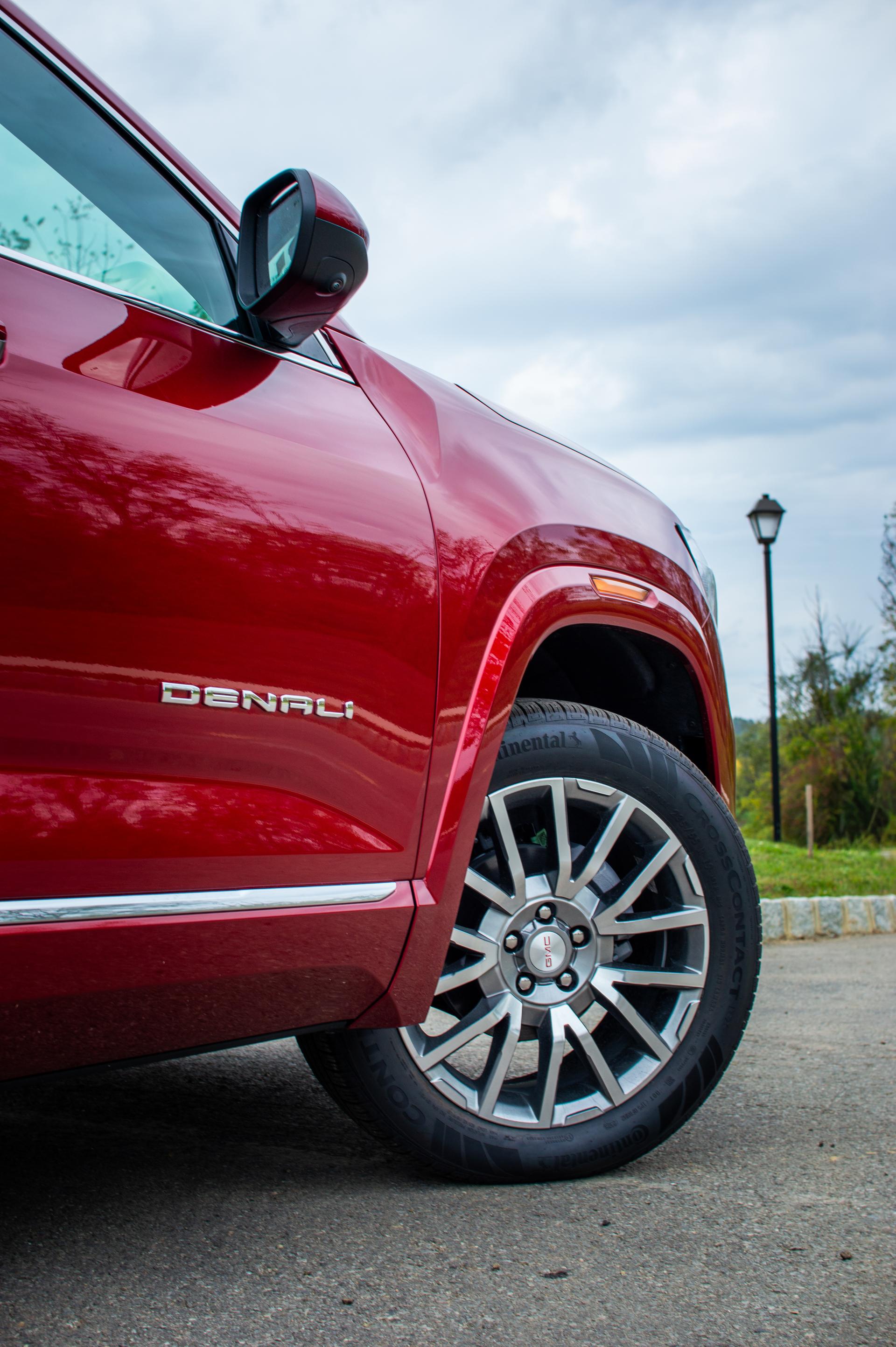 2026 GMC Terrain Denali in Volcanic Red in front of a Warren County, NJ home, highlighting premium wheels and upscale chrome accents