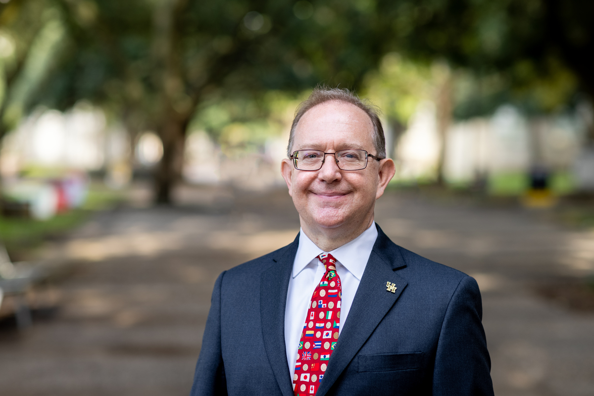 Photo of Michael Pelletier outside wearing blue jacket, red tie