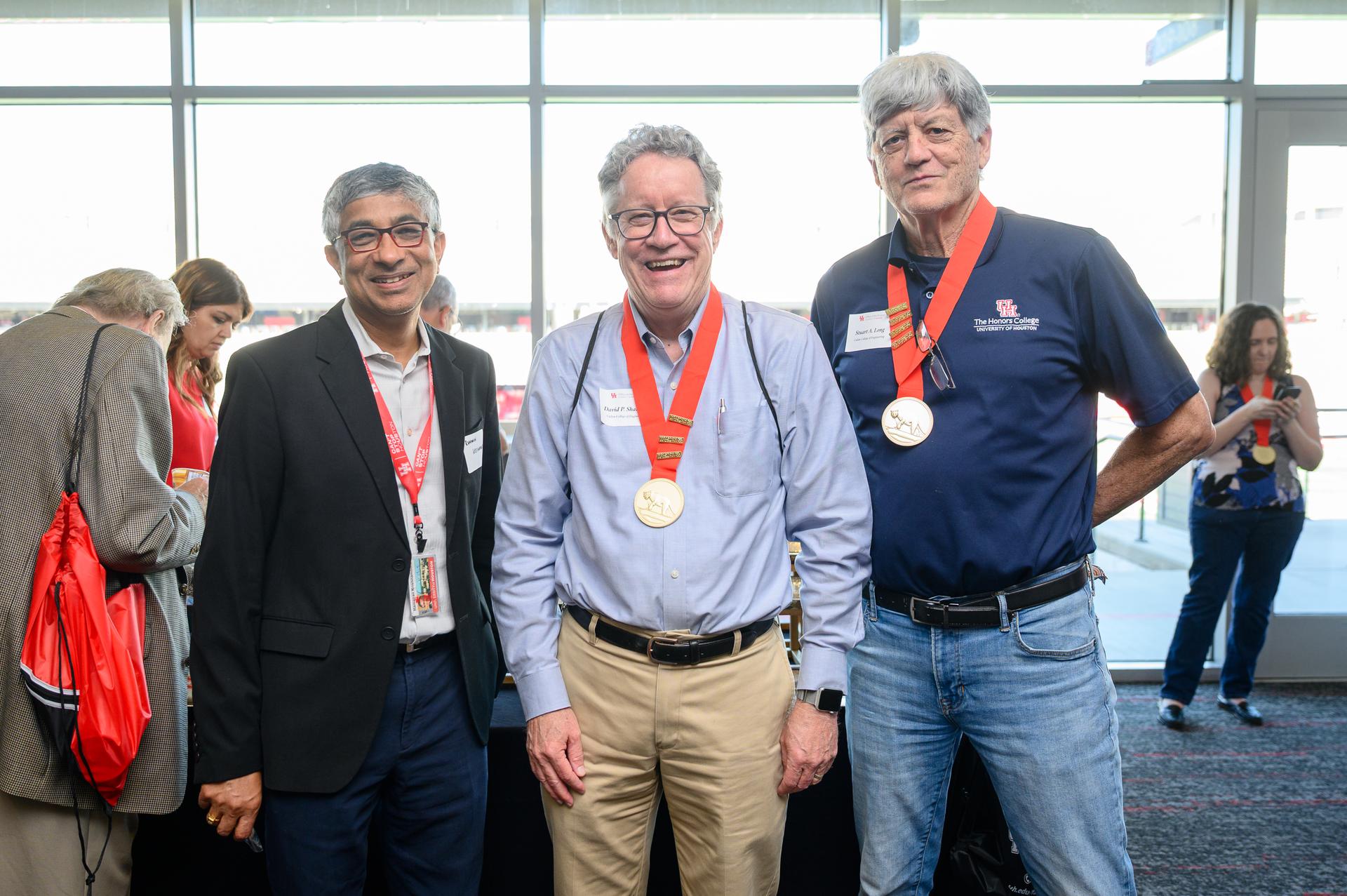 photo of three faculty members wearing their medallions