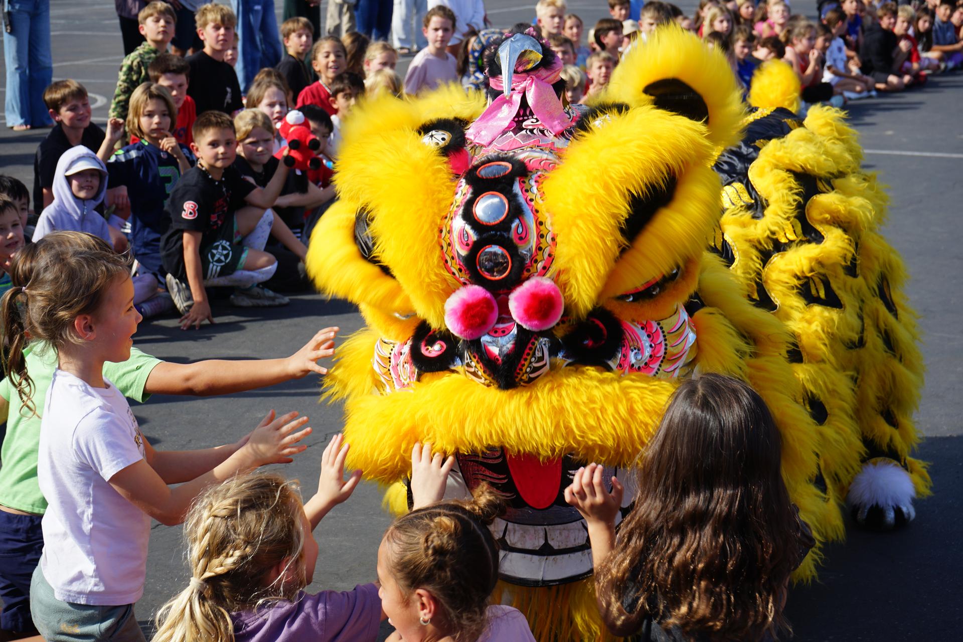 Two students stand in front of their science fair board, holding a certificate and an egg.
