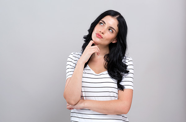 Woman with long, dark hair thinking