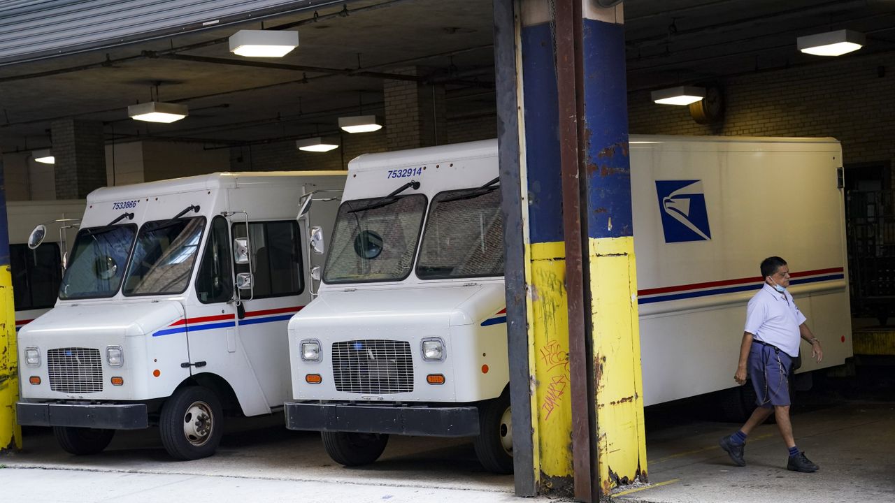 A USPS worker leaves his truck after parking in the Canal Street station loading bay in New York City. [AP Photo/ John Minchillo]
