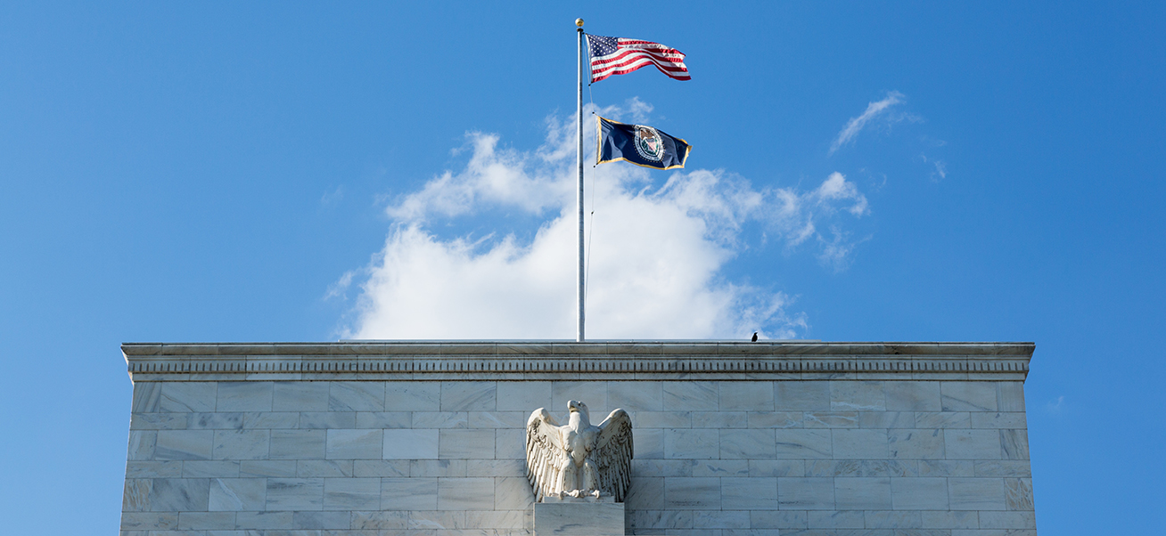 a flag on a flagpole on top of the federal reserve building in DC