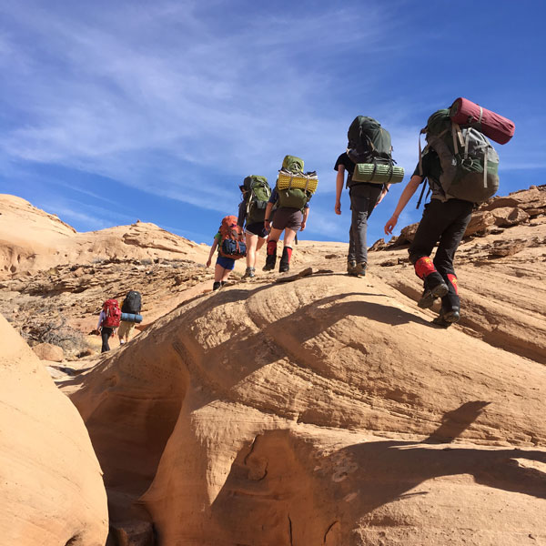 Backpackers trekking over dry terrain on a sunny day