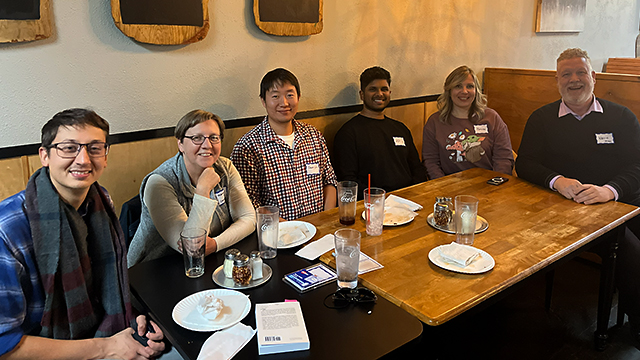 Six people sit around a table at a restaurant.