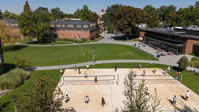 An overhead view of a sand volleyball game in progress.