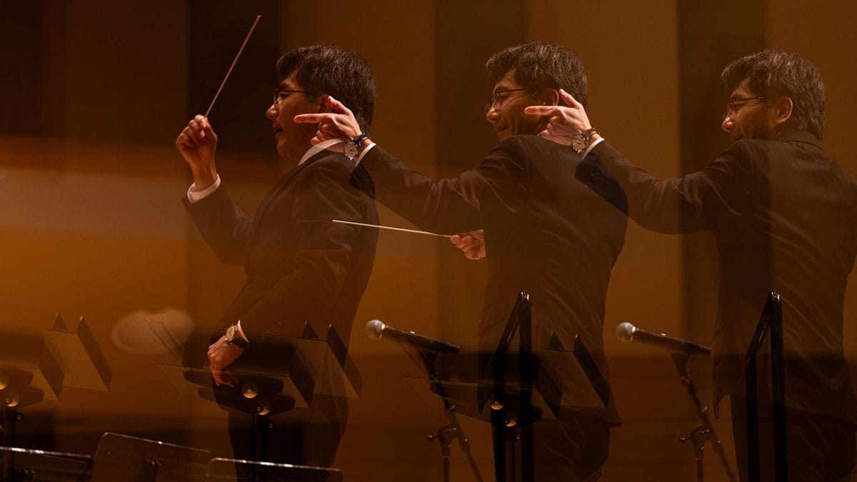 Three overlapping images of a conductor in action.