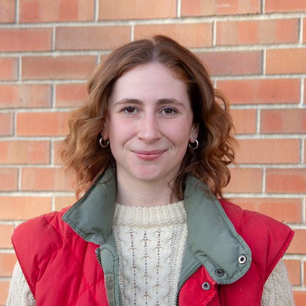 Annie Means standing in front of a brick wall