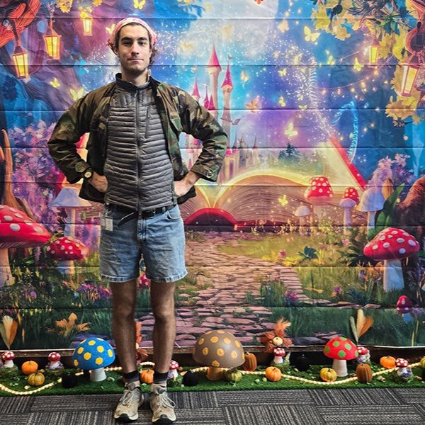 Micah Powch stands in front of a fairy tale backdrop