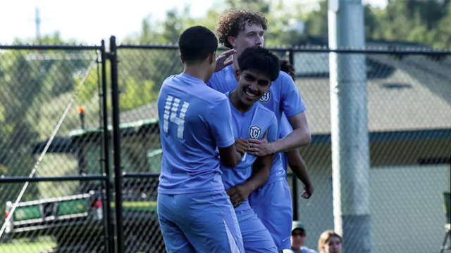Three soccer players celebrating.