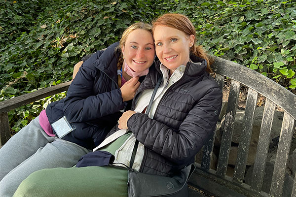 Siena Hayes (left) sits on a wooden bench with her mother (right).