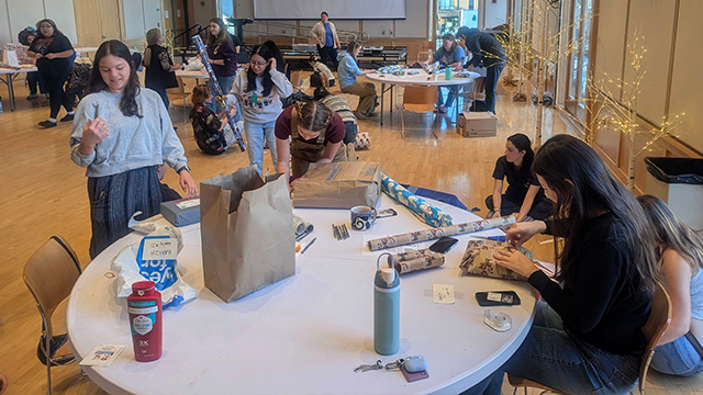 People wrapping gifts in the Reid Campus Center ballroom.