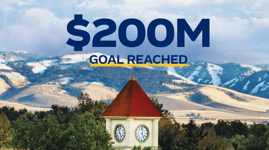 An image of the top of the clock tower on Memorial Building, with dark blue text above: “$200M Goal Reached.”