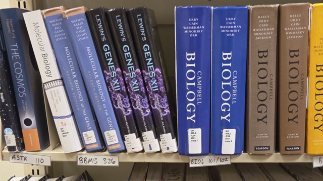 An assortment of Biology textbooks on a shelf