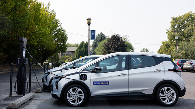 An electric car plugged in at a charging station.