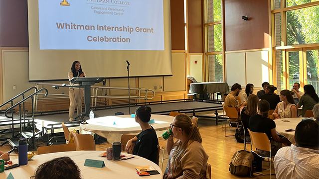 Nadine Stecklein speaking at a lectern in the Reid Ballroom in front of an audience of people seated at round tables. 